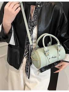 Mint green patent leather cylindrical Boston bag with shoulder strap and metal logo