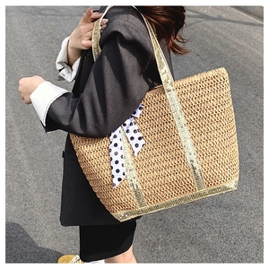 Détail du sac cabas en paille avec ruban à pois et bordures dorées métallisées