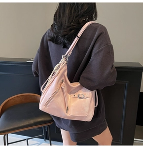 Macro detail of soft pink faux leather tote bag with functional pockets and zippers