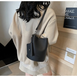 Detail of black lychee grain leather bucket bag with a detachable small square pouch