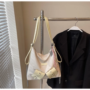 Détail du sac fourre-tout blanc cassé avec anses jaunes et élégante chaîne décorative