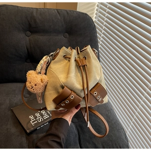 Nahaufnahme der Canvas-Beuteltasche mit Ledertaschen und süßem Bär-Schlüsselanhänger