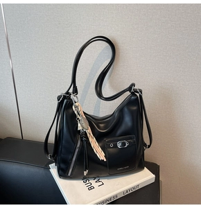 Detailed close-up of a large black Hobo bag featuring a front pocket and silver hardware