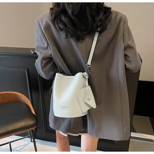 Detail view of light blue lychee pattern leather bucket bag with mini envelope pouch
