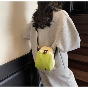 Detailed view of the mini nylon shell bag with vibrant green and yellow contrast colors
