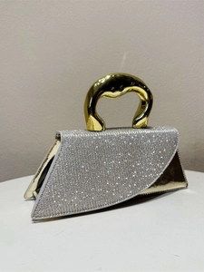 Elegant gold handbag with silver crystal flap and curved top handle for evening wear