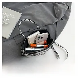 Detailansicht der Schlangenhaut-Muschel-Tasche mit Platz für Handys und Lippenstifte