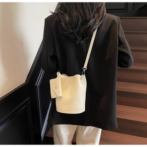 Detail of cream lychee texture bucket bag with detachable pouch and silver hardware