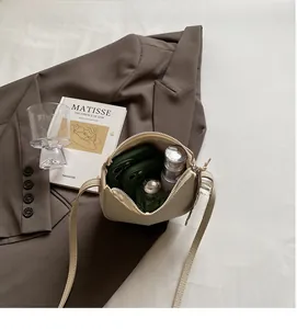 Vue de dessus du sac selle crème montrant l'intérieur spacieux pour téléphone