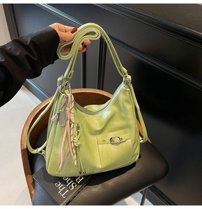 Detail of avocado green soft leather tote with silk scarf and tennis racket charm