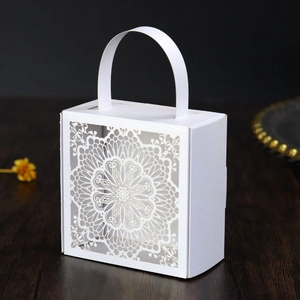Detalle del patrón de mandala blanco cortado con láser en la caja de regalo cuadrada