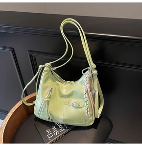 Detail of lime green leather tote showing front zipper pocket and metal buckle texture
