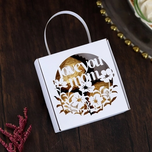 Macro shot of white laser-cut Mother's Day gift box with Love You Mom floral design