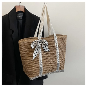 Detail of straw tote bag with silver sequins, polka dot ribbon, and woven handles