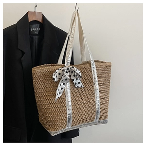 Detail of straw tote bag featuring sequin handle and polka dot bow scarf decoration