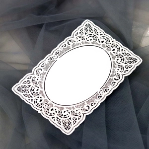 Détail d'une carte en papier dentelle blanc découpée au laser avec motifs floraux