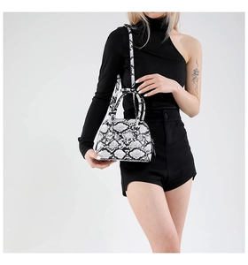 Detail of snakeskin print shell bag with textured PU leather finish and crossbody strap