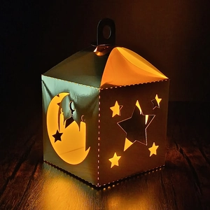 Macro shot of laser-cut green star lantern with moon patterns and warm interior lighting