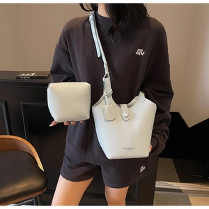 Detail of mint green lychee grain leather bucket bag with matching mini pouch and logo