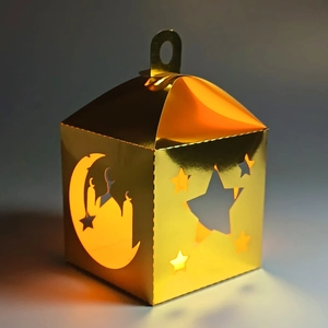Detail of laser-cut golden star and moon lantern with mosque silhouette and warm light