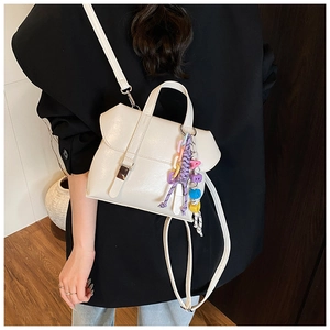 Close-up of off-white PU leather bucket bag with decorative colorful bead charm and metal buckle