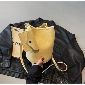 Detail of light yellow bucket bag with pebbled leather texture and mini envelope pouch