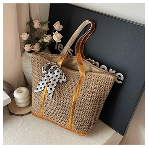 Straw tote bag detail with golden sequin handle and black white polka dot ribbon
