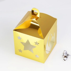 Close-up of golden hollow star and moon gift box with metallic finish and handle