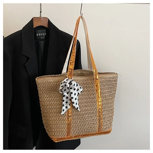 Detail of straw tote bag featuring sequin trim and a black and white polka dot bow