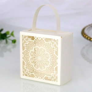 Detalle de caja de regalo blanca troquelada por láser con diseño de encaje y asa curva