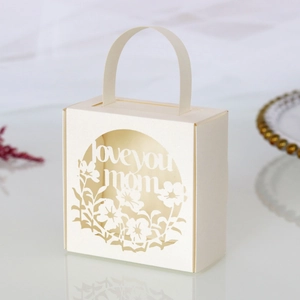 Macro detail of laser cut floral pattern and love you mom text on pearl paper gift box