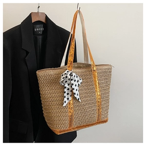 Détail du cabas en paille tissée avec paillettes orange et nœud ruban à pois