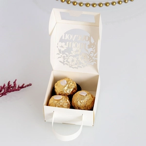 Macro view of laser-cut Love You Mom candy box with floral hollow details and ribbon