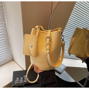 Detailed view of yellow litchi pattern bucket bag with matching mini pouch accessory