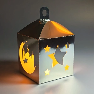 Macro view of silver star and moon hollowed-out festive lantern with warm light