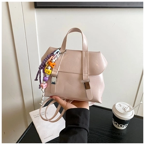 Pink glossy leather handbag detail with colorful letter bead charms and silver buckles