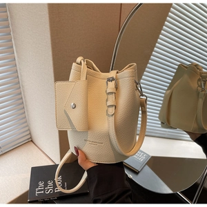 Close-up of cream white lychee leather bucket bag with matching card holder pouch