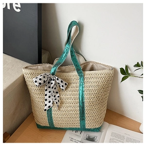 Détail du sac en paille avec paillettes vertes, foulard à pois et fermeture éclair