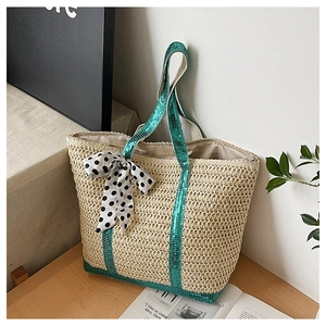 Detail of straw tote bag with green sequins, polka dot bow and large capacity interior