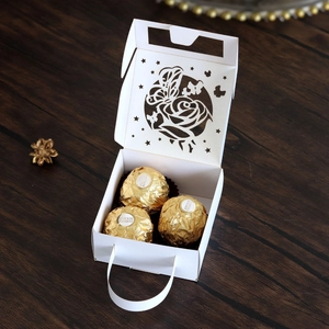Detail of white laser-cut gift box with hollow butterfly rose pattern and handle