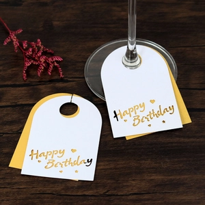 Detalle de tarjetas Happy Birthday para copas en cartulina blanca y dorada elegante