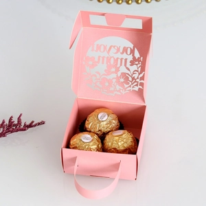 Detail of pink laser-cut gift box with Love You Mom engraving and chocolates