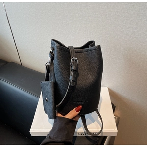 Detail of black lychee grain leather bucket bag with adjustable strap and small coin purse