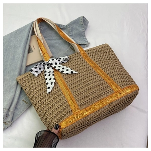 Macro shot of large straw tote with golden sequin straps and a polka dot ribbon bow