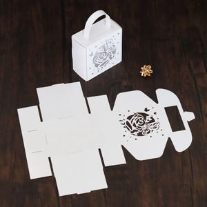 Detail of white laser-cut paper gift box featuring hollow butterfly and rose designs