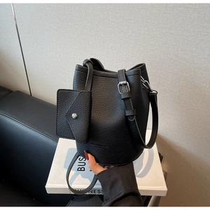 Detail of black lychee grain leather bucket bag with silver hardware and small pouch