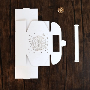 Flat lay of unassembled white laser-cut butterfly gift box with flower patterns