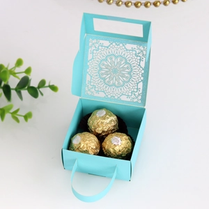 Detalle de la caja de regalo azul claro con diseño floral cortado con láser y asa