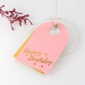 Detalle de tarjetas de copa Happy Birthday rosa y dorado con diseños troquelados