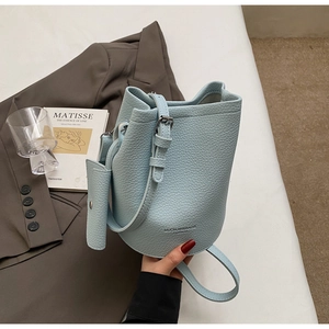 Detail of light blue lychee pattern bucket bag with mini pouch and adjustable strap